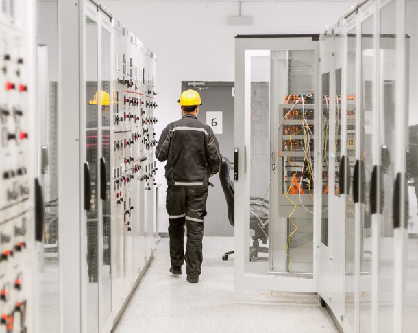 Worker in electrical suit works on Hoffman modified control panel.